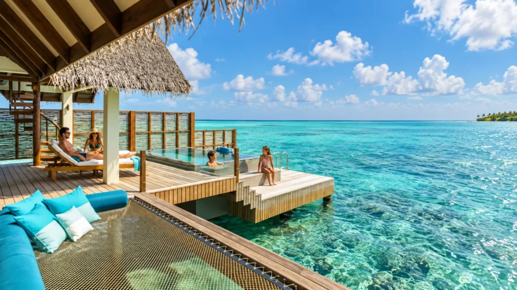 Family on a shallow sandy beach at a Maldives resort