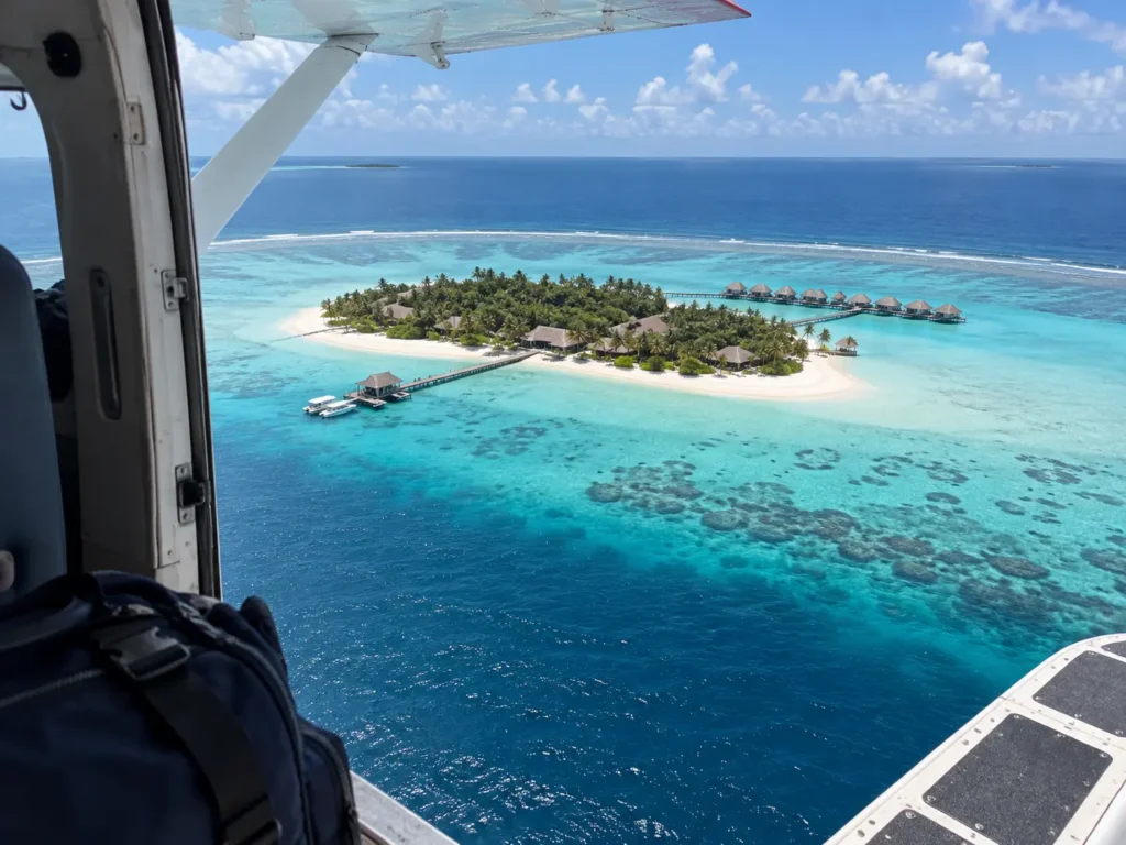Aerial view of a Maldives island ringed by reef and turquoise lagoon